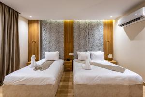 two beds in a hotel room with white sheets at Pyramids sunrise inn in Cairo