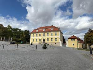 a large yellow building with a red roof on a street at Ferienwohnung im Zentrum von Ballenstedt in Ballenstedt