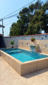 a large swimming pool in a brick wall at Casa com piscina climatizada em Itanhaém! in Itanhaém