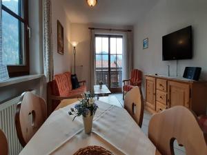 贝里斯泽尔Lush apartment in Bayrischzell with 2 saunas的带桌椅和电视的客厅