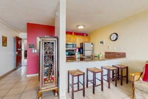a kitchen with a bar and stools in a room at Kona Reef Comfort D6 in Kailua-Kona