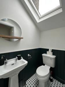 ハワースにあるBronte Hideawayの白いトイレと洗面台のあるバスルーム