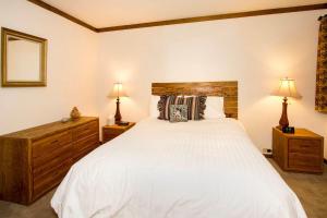 a bedroom with a large white bed with two lamps at Mammoth Point #129 - Balcony with Mountain Views in Mammoth Lakes