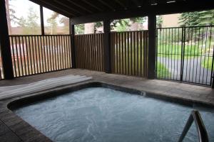 a swimming pool in a backyard with a wooden fence at Mammoth Point #129 - Balcony with Mountain Views in Mammoth Lakes