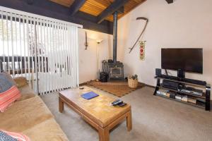 a living room with a couch and a coffee table at Mammoth Point #129 - Balcony with Mountain Views in Mammoth Lakes +11 photos