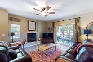 a living room with a leather couch and a ceiling fan at Northshore Lakeview Getaway in Bass Lake