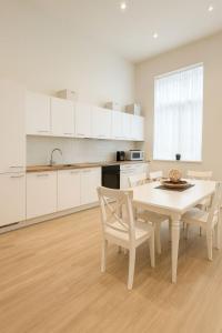 a white kitchen with a white table and chairs at The Gallery Saint-Gilles in Brussels +40 photos