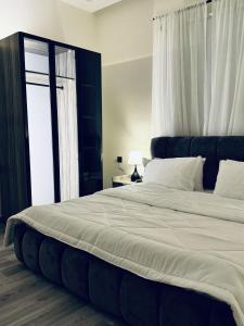 a large bed in a bedroom with a window at Modern Apartment 2 in Jeddah