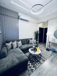 a living room with a couch and a table at Modern Apartment 2 in Jeddah