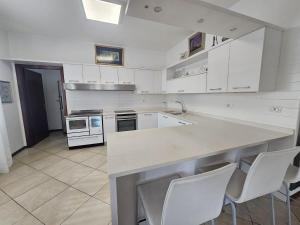a kitchen with white cabinets and white appliances at Amanda Apartments in Sarche di Calavino