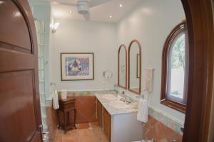 ein Badezimmer mit Waschbecken und Spiegel in der Unterkunft Villa Marrakesh, Cupecoy Beach - A Luxury Villa with Pool in Lowlands