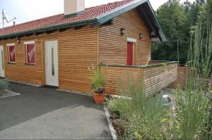 a small wooden house with a porch and a driveway at FreeWest in Pirkhof +5 photos
