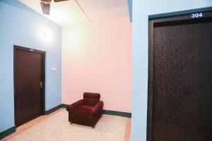 Zimmer mit einem roten Stuhl und einer Tür in der Unterkunft Hotel O PG Guest House in Tangra