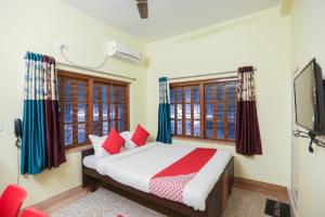 ein Schlafzimmer mit einem Bett und einem Fernseher und Fenstern in der Unterkunft Hotel O PG Guest House in Tangra + 37 Fotos