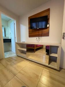 a entertainment center with a flat screen tv on a wall at Pousada vida e mar in Balneário Camboriú