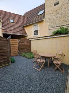 a patio with a table and chairs and a fence at Cœur de Villers in Villers-Saint-Paul