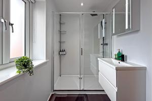 a white bathroom with a shower and a sink at Contractors Heaven-POOL TABLE-THREE BEDROOM HOUSE WITH SEPARATE ONE BEDROOM SELF CONTAINED-Close to AIRPORT in Luton