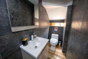 a bathroom with a white sink and a toilet at 6 Habitaciones con un Jacuzzi Privado in Medellín +14 photos