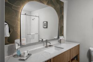 a bathroom with a sink and a large mirror at The Grove Hotel in Boise