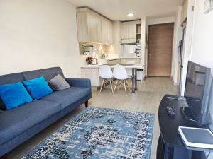 a living room with a blue couch and a kitchen at Claro Centro Temuco in Temuco