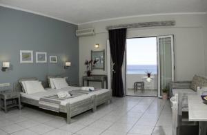 a bedroom with a bed and a balcony with the ocean at Artemis Studios in Plakias