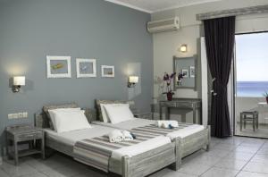 a bedroom with two beds and a view of the ocean at Artemis Studios in Plakias