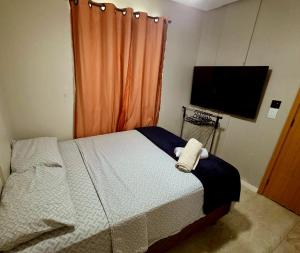 a bedroom with a bed and a flat screen tv at Salt Beach Atalaia Residence Inn in Salinópolis