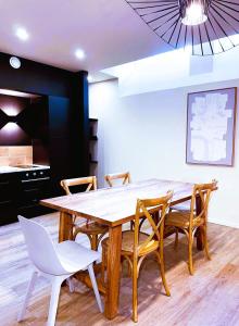 una sala da pranzo con tavolo e sedie in legno di Cancùn - Appartement Spa Privatif a Reims