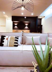 un divano bianco in soggiorno con una pianta di Cancùn - Appartement Spa Privatif a Reims