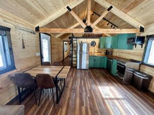 a kitchen with green cabinets and a wooden floor at Index Peak Cabin  +4 photos