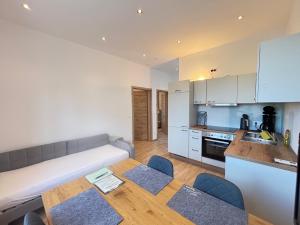 eine Küche und ein Wohnzimmer mit Sofa und Tisch in der Unterkunft Gästewohnung, Hauptplatz 3 Kautzen in Kautzen