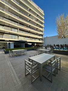 eine Gruppe Picknicktische vor einem Gebäude in der Unterkunft MOVISTAR ARENA PREMIUM THAMES 56 8 piso 812 Cocheras y Seguridad in Buenos Aires