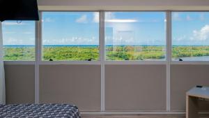 レシフェにあるPaiva Home Stay - Flat Beira-Mar em Barra de Jangada por Yoloの海の景色を望む窓4つが備わる客室です。