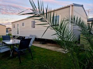 an rv with a table and chairs in front of it at Birchington Vale Trieste - Sleeps 8, pet friendly & Family friendly in Birchington