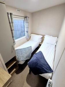two beds in a small room with a window at Birchington Vale Trieste - Sleeps 8, pet friendly & Family friendly in Birchington