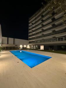 ein Schwimmbad vor einem Gebäude bei Nacht in der Unterkunft MOVISTAR ARENA PREMIUM THAMES 56 8 piso 812 Cocheras y Seguridad in Buenos Aires