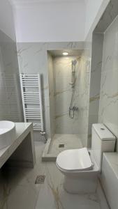 a white bathroom with a toilet and a sink at Neoclassical apartment in kadmia in Thiva