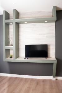 a living room with a flat screen tv on a wall at Joli appartement neuf Proche gare Pèlerins et pro in Le Puy en Velay