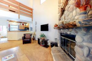 a living room with a large stone fireplace at Silverpick #303 - River Rock Retreat in Durango