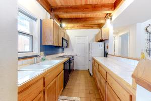 a kitchen with wooden cabinets and a white refrigerator at Silverpick #303 - River Rock Retreat in Durango