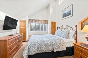 a bedroom with a bed and a dresser and a tv at Silverpick #303 - River Rock Retreat in Durango