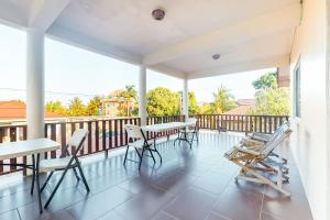 a porch with tables and chairs on a balcony at Grama Tasha at Isebei Guest House -Gold Standard Certified in Hopkins