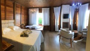 a bedroom with a bed with a stuffed animal on it at Chalé Recanto do Pimenta e Casa Recanto do Pimenta in Pedra Azul