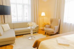ein Hotelzimmer mit einem Bett, einer Couch und einem Stuhl in der Unterkunft CORNER HOUSE in Lučenec