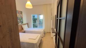 a hotel room with two beds and a window at Kemer House Apartments in Kemer