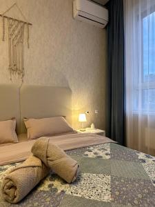 a bedroom with a bed with a towel on it at Уютная квартира 5 минут от Барыс арены in Astana