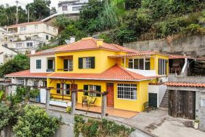 una casa gialla sul fianco di una collina di Sol Poente by GALMI a Santo António