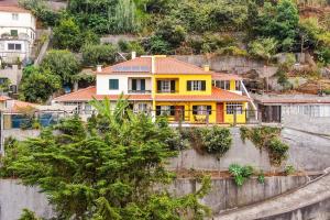 una casa gialla sul fianco di una montagna di Sol Poente by GALMI a Santo António