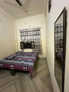 1 dormitorio con cama y espejo. en Nidhivan Vatika Ashram, en Vrindāvan