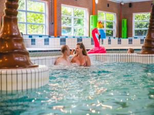 a man and a woman in a swimming pool at Villa in Friesland with Garden by Water in Andijk